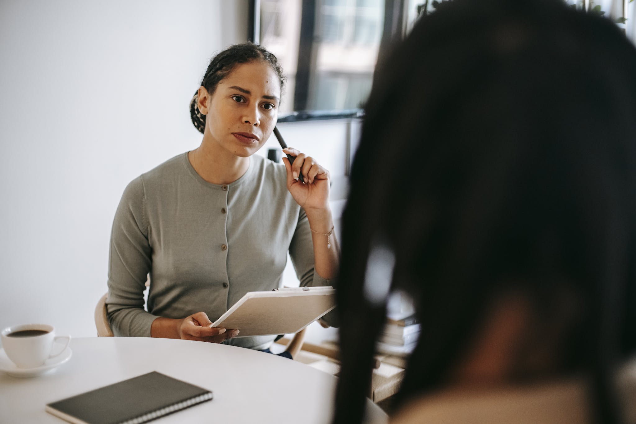 Serious ethnic psychotherapist listening to clients complains